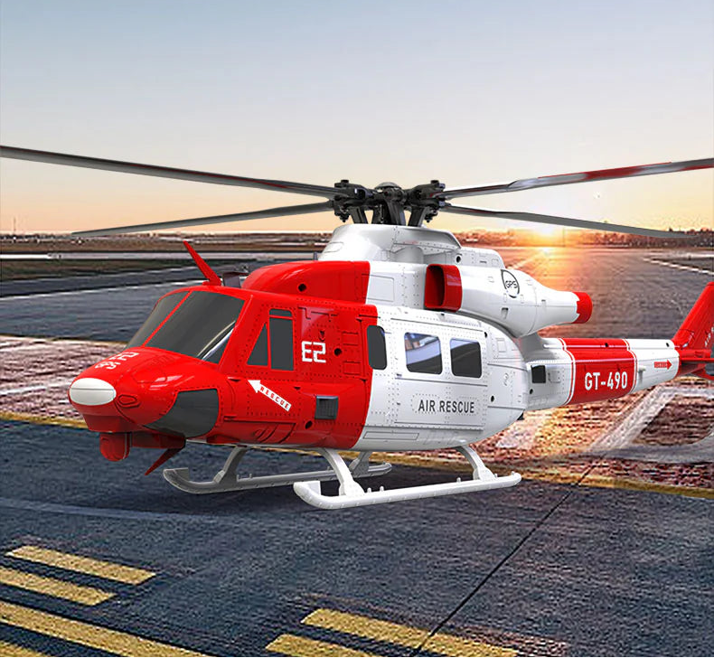 Red and white helicopter on a runway with a sunset in the background