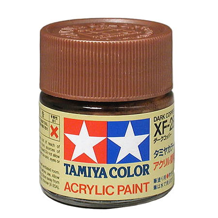 A small jar of Tamiya Color acrylic paint with a ribbed brown cap and a cream label featuring the red and blue Tamiya logo, shown on a neutral gray background.